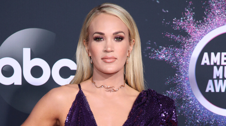 Carrie Underwood posing in purple sequin dress