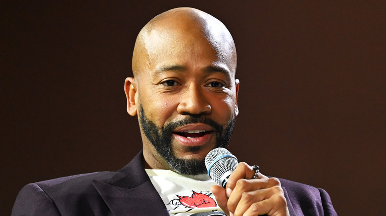 Columbus Short holding microphone