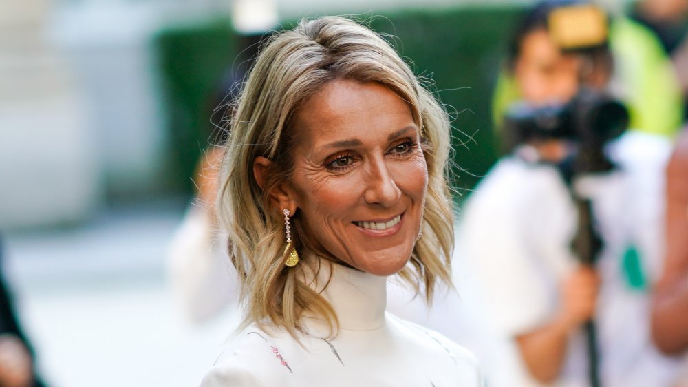 Céline Dion smiling in white turtleneck top