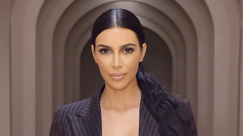 Kim Kardashian with hair in low pony and in a black blazer