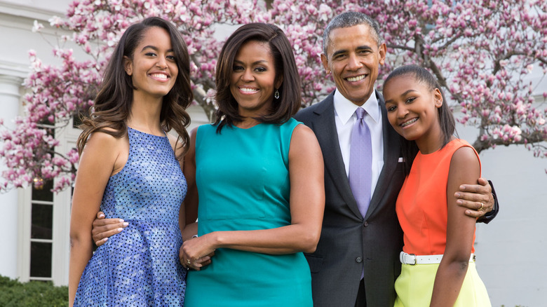 Michelle Obama posing with her husband and daughters