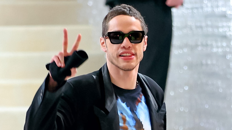 Pete Davidson posing, throwing up peace sign