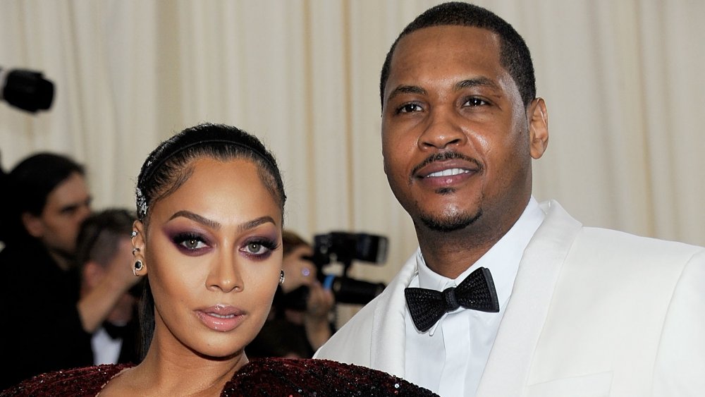 La La Anthony in a maroon sparkly dress, Carmelo Anthony in a white suit with black bow-tie