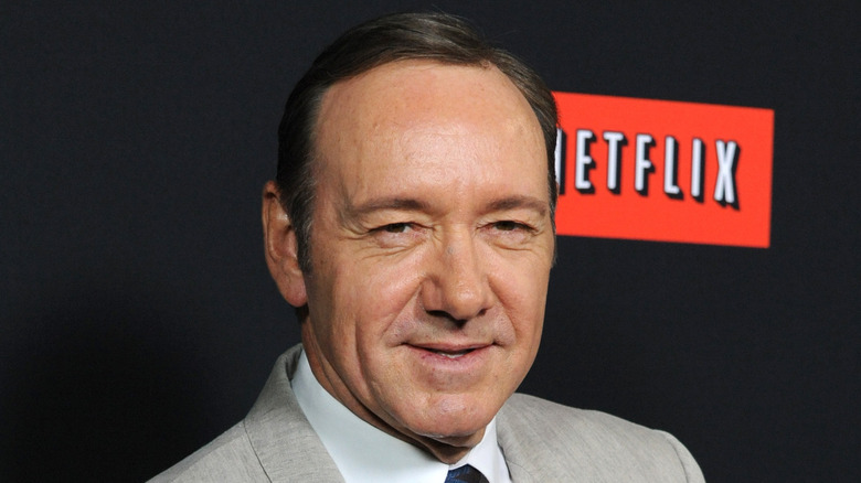 Kevin Spacey posing in front of Netflix sign