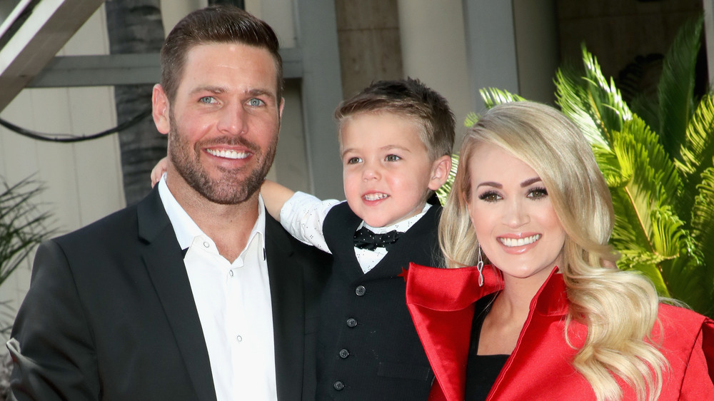 Carrie Underwood, Mike Fisher, and their son at an event