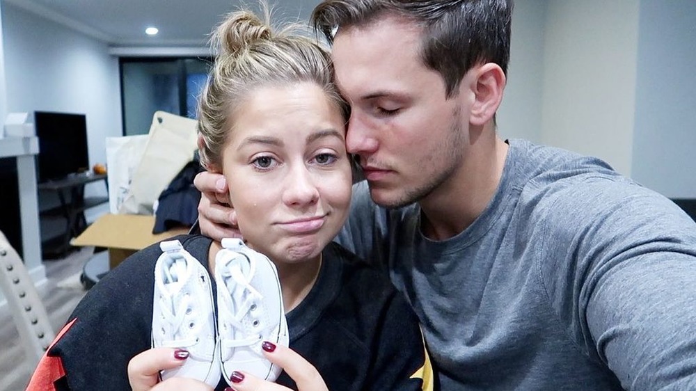 Shawn Johnson and her husband Andrew East holding baby shoes