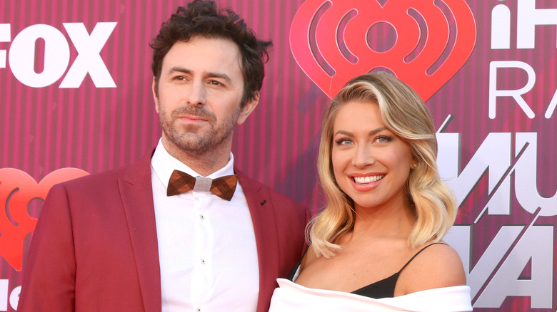 Stassi Schroeder and Beau Clark in front of red background
