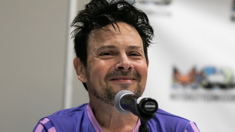 Jason Marsden smiling by microphone at a comic con