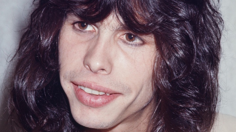 Steven Tyler mid-70s dark hair looking pensive 