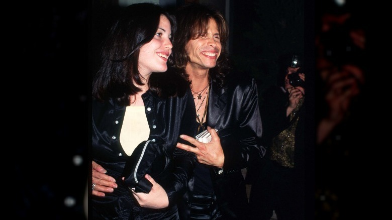 Steven Tyler and Liv Tyler posing in matching satin suits 90s
