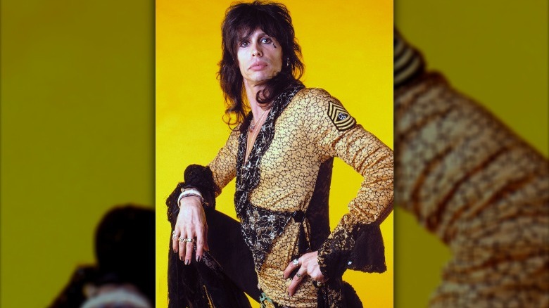 Steven Tyler posing in yellow frilly outfit 80s