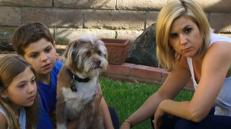 Brandi Passante crouching down beside children and dog