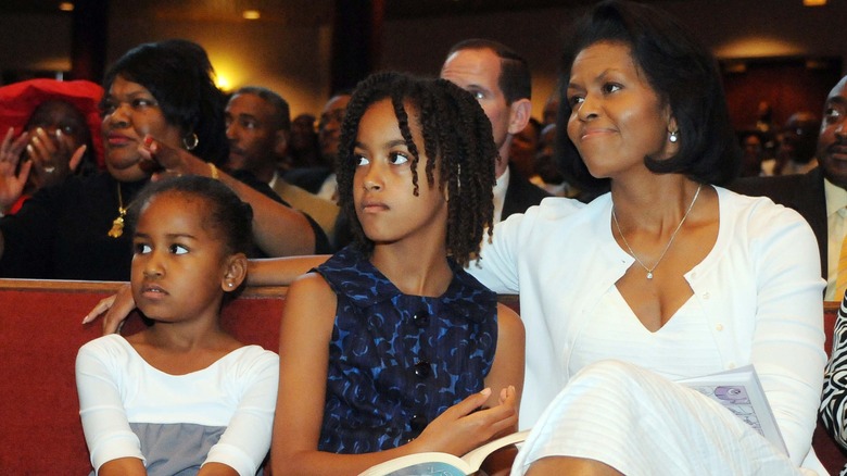 Michelle Obama and daughters listening