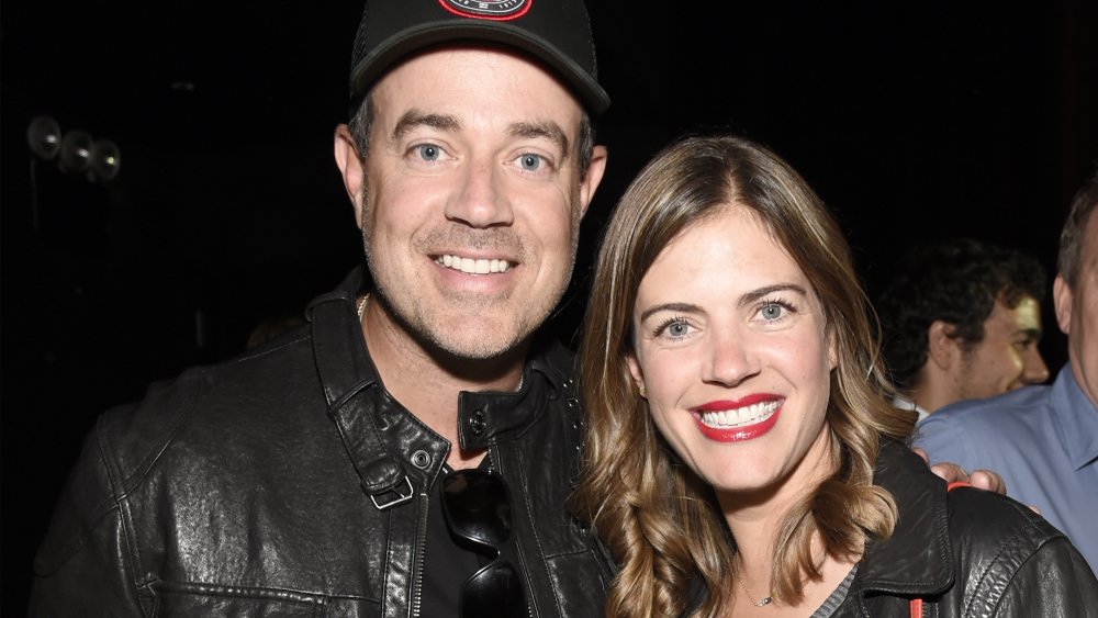 Carson Daly with a hat and arm around Siri Pinter