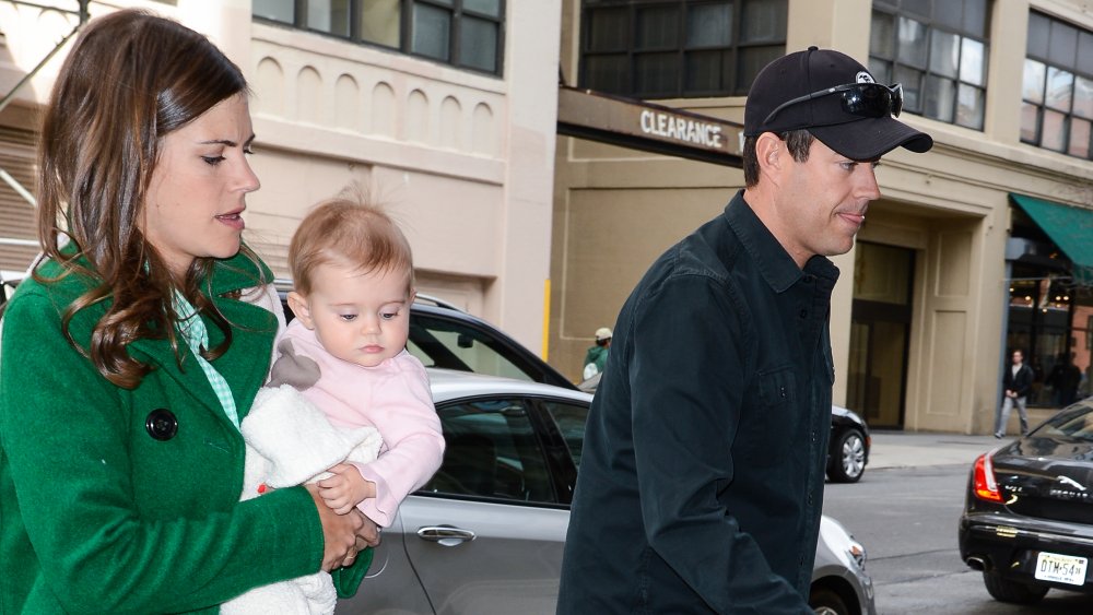 Siri Pinter carrying baby, and Carson Daly walking 