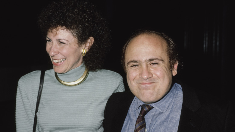 Rhea Perlman and Danny DeVito stand together in the 1990s