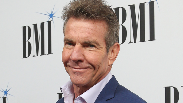 Dennis Quaid smiling on a red carpet