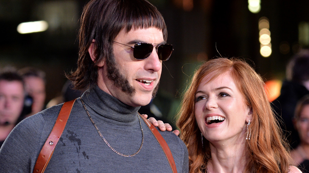 Sacha Baron Cohen in character alongside Isla Fisher laughing at the premiere of The Brothers Grimsby 