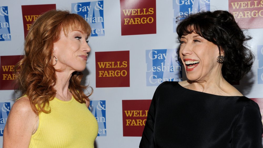 Kathy Griffin smirking at a laughing Lily Tomlin at an event