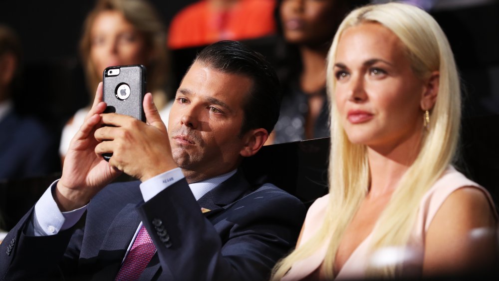 Donald Trump Jr. taking a photo on his phone next to Vanessa Trump