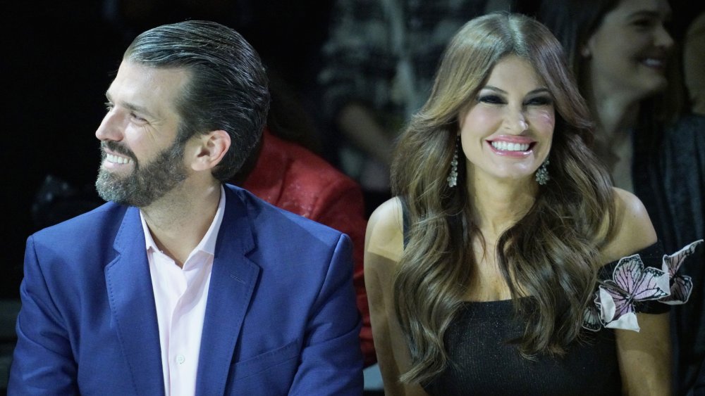 Donald Trump Jr. and Kimberly Guilfoyle both sitting down and smiling