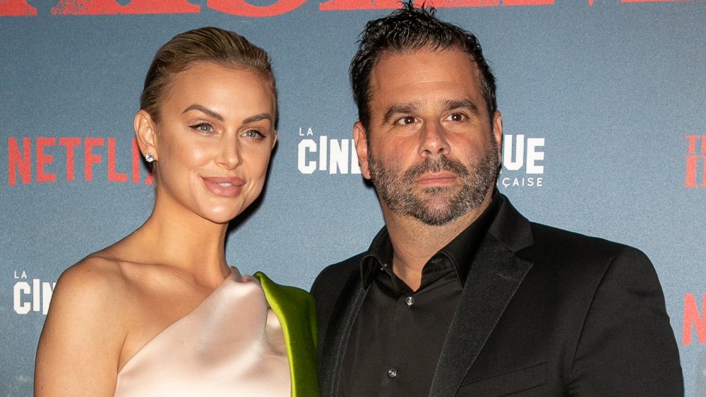 Lala Kent in a pink dress, Randall Emmett in a black suit, attending a Netflix premiere