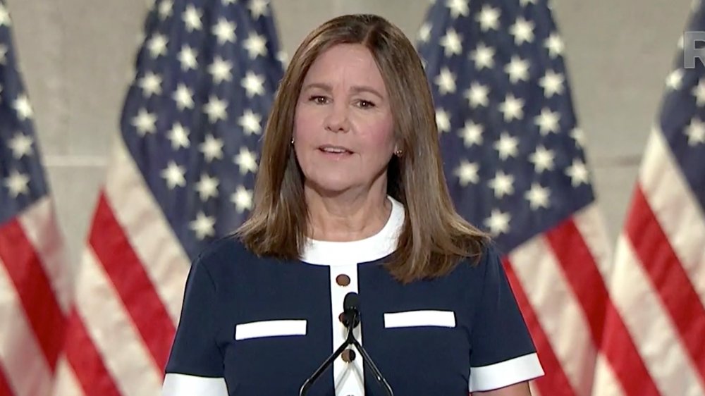 Karen Pence speaking at a podium in front of USA flags