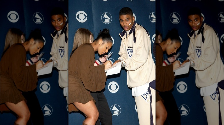 Ashanti signing her autograph for Nelly in 2003