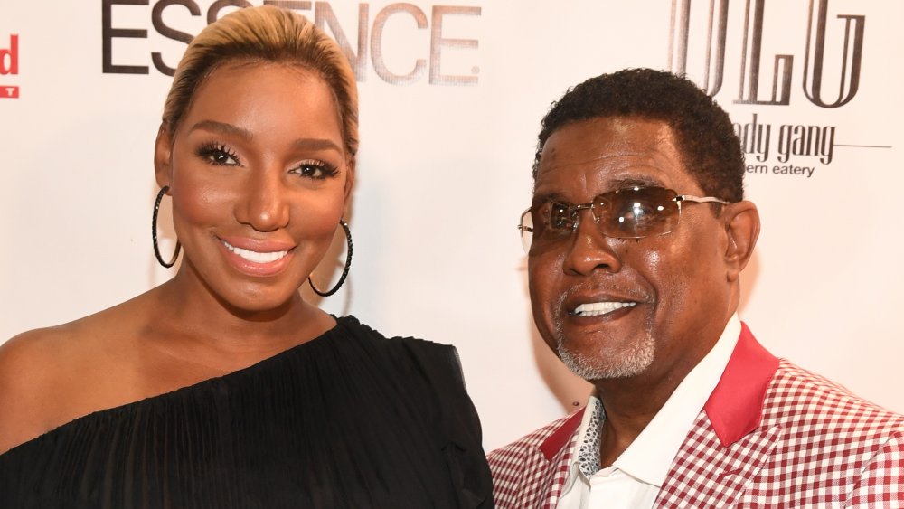 NeNe Leakes in a black dress and hoop earrings, Gregg Leakes in a red plaid suit