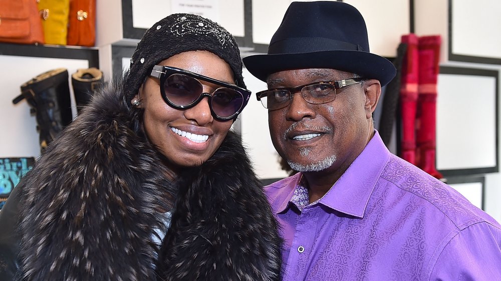 NeNe Leakes in a black-and-brown coat, hat, and sunglasses, and Gregg Leakes in a purple shirt and black hat