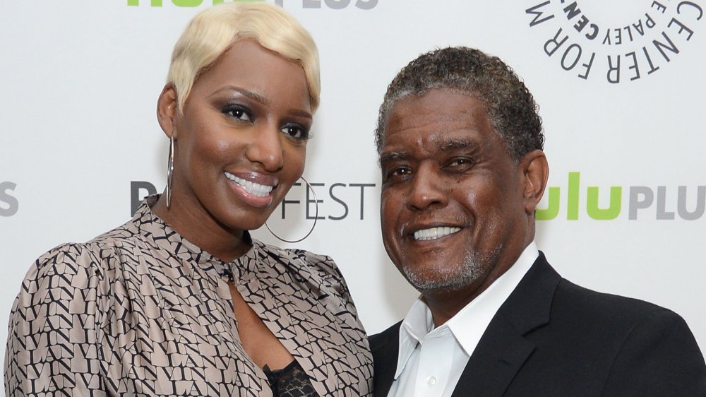 NeNe Leakes in a beige-and-black top with short blonde hair, Gregg Leakes in a classic black-and-white suit