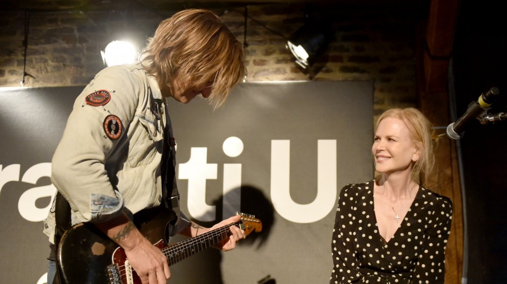 Nicole Kidman smiling while watching Keith Urban play guitar