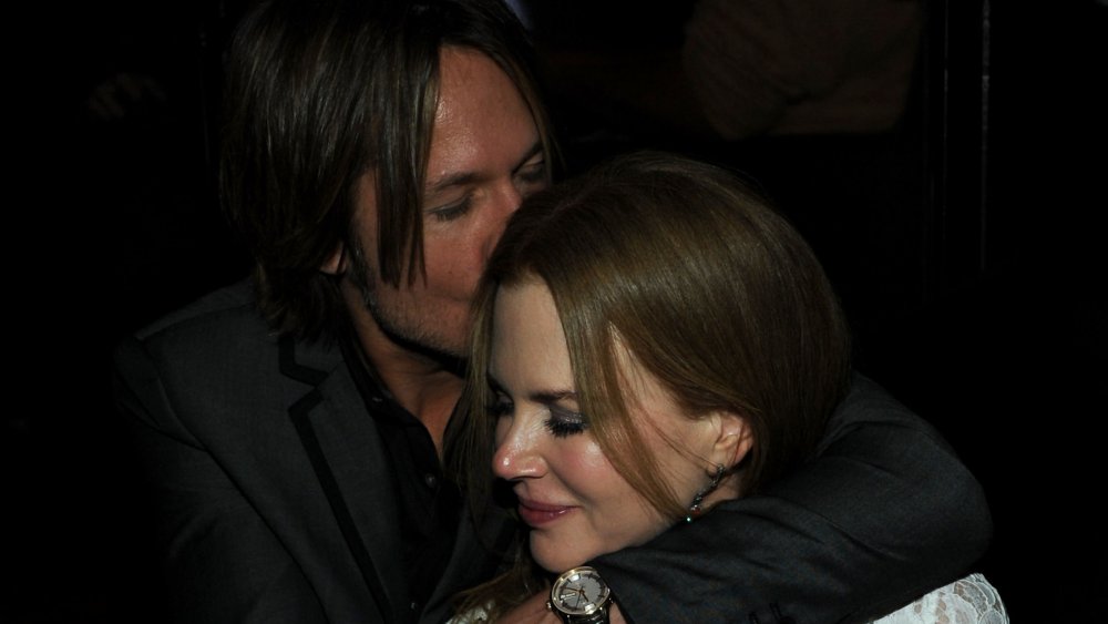 Keith Urban kissing Nicole Kidman's head, with his arms around her shoulders