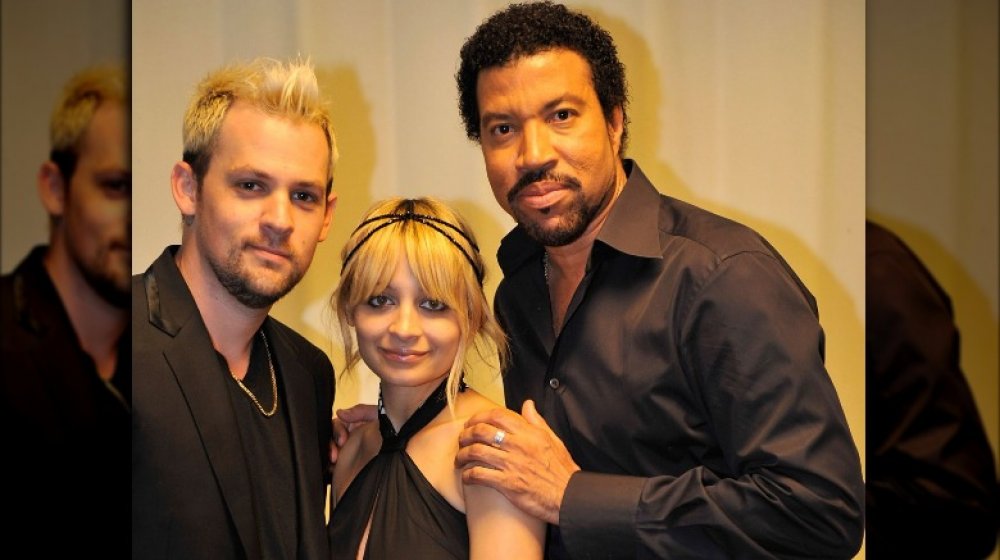 Joel Madden, Nicole Richie, and Lionel Richie posing together, all wearing black