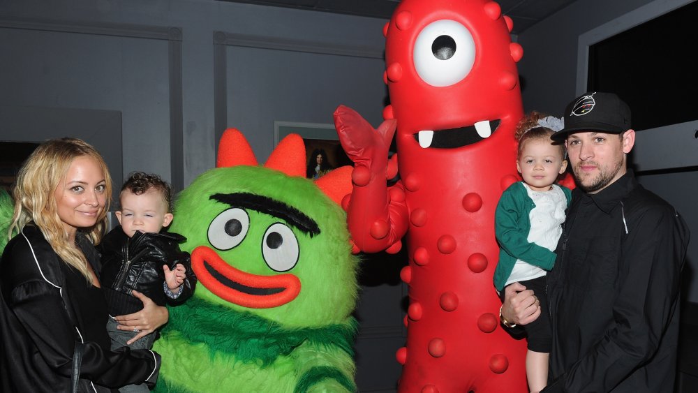 Nicole Richie and Joel Madden holding their kids at a Yo Gabba Gabba! event in 2010