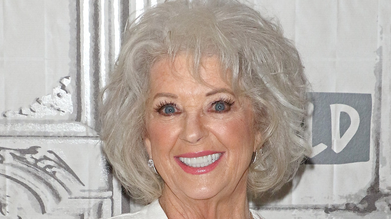 Paula Deen smiles in white