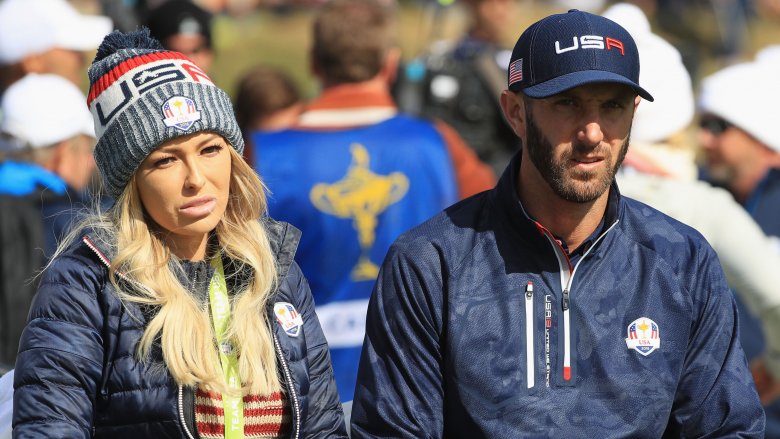 Paulina Gretzky and Dustin Johnson, sitting next to each other, both with serious expressions