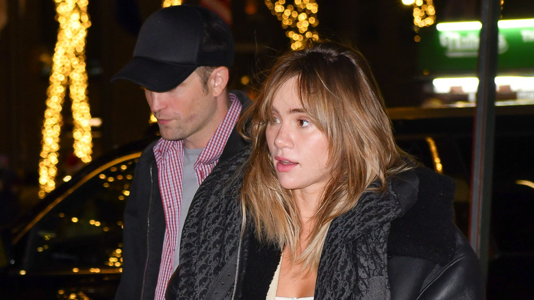 Suki Waterhouse and Robert Pattinson walking down the street