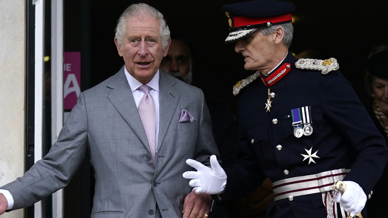 Prince Charles speaking with an aid