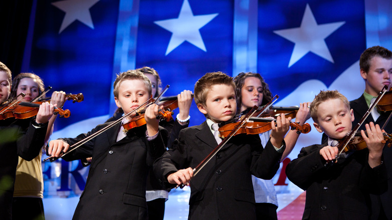 The Duggar family playing violins