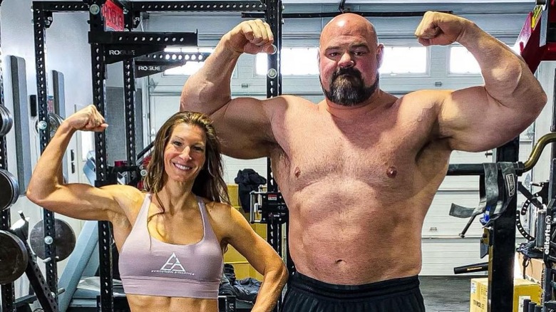 Keri and Brian Shaw flexing their arms in the gym