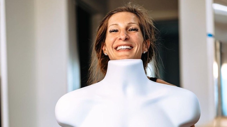 Keri Shaw smiling behind a white mannequin torso