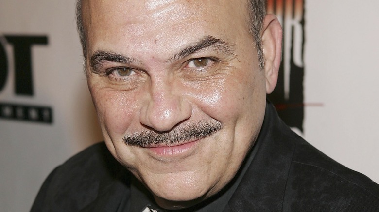 Jon Polito in dark shirt and tie