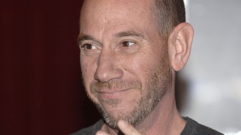 Miguel Ferrer smiles and looks off camera