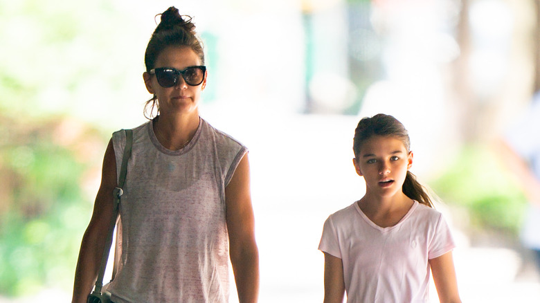 Suri Cruise and Katie Holmes walk in a city