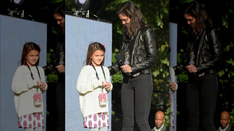 Katie Holmes looking down at frowning Suri Cruise