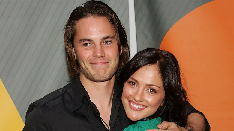 Taylor Kitsch and Minka Kelly embracing and smiling