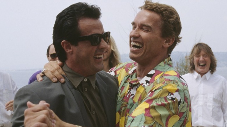 Sylvester Stallone and Arnold Schwarzenegger laughing