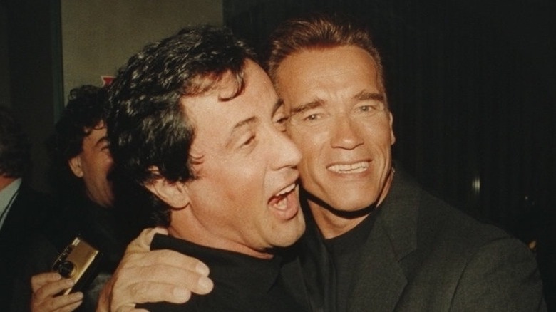 Sylvester Stallone and Arnold Schwarzenegger hugging