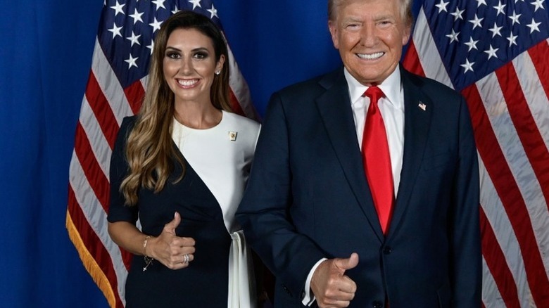 Alina Habba and Donald Trump standing in front of American flags, giving the thumbs up